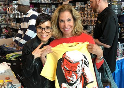 debra holding up a t shirt at comic con